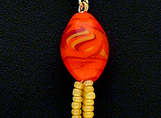 Bižuterie a stříbrné šperky - 556, Jednoduchý náhrdelník tvoří šňůrka ze žlutého rokailu, zdobená přívěskem z žíhaného lampového korálku oranžové barvy a krátkého rokailového střapce.